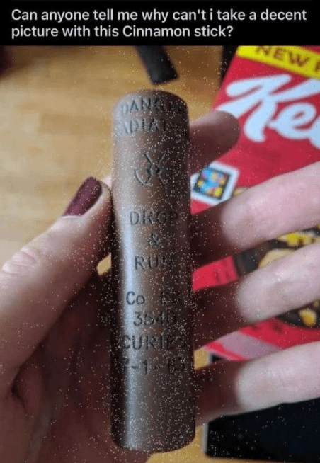 Title: Can anyone tell me why can't I take a decent picture with this cinnamon stick?

Below is a photo of someone holding a stick of radioactive material on their hand. There are white dots around it due to the radiation.