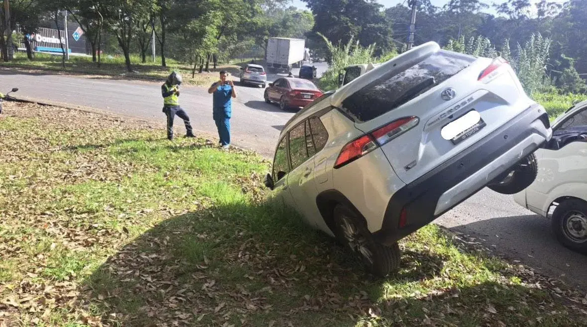 A car is stuck in the ground at a weird 30°-ish angle. It looks like in a video game where a car clipped through the ground.