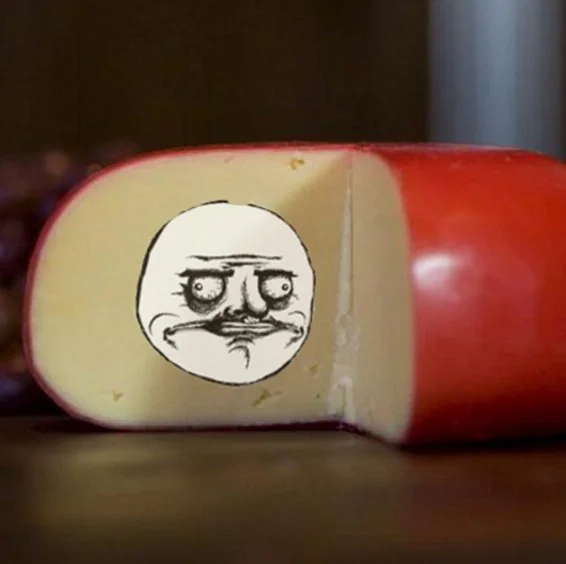 An open wheel of cheese with a "me gusta" face placed on it.